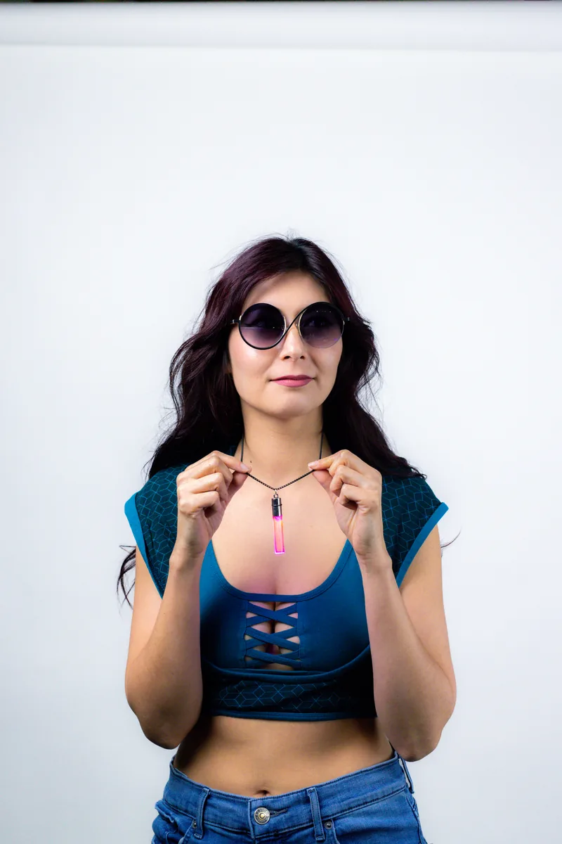 Model holding up a Pink Pulse GloNova pendant